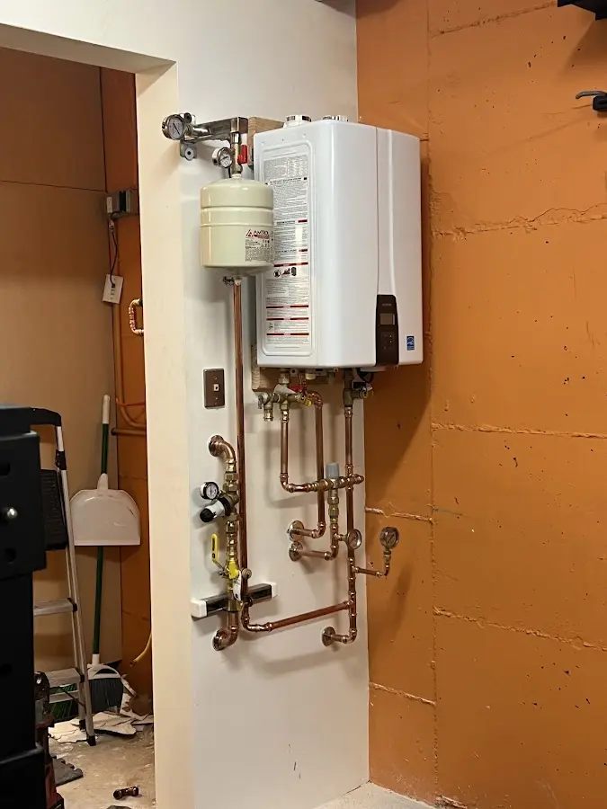 Plumbing technician inspecting water heater connections in Alachua